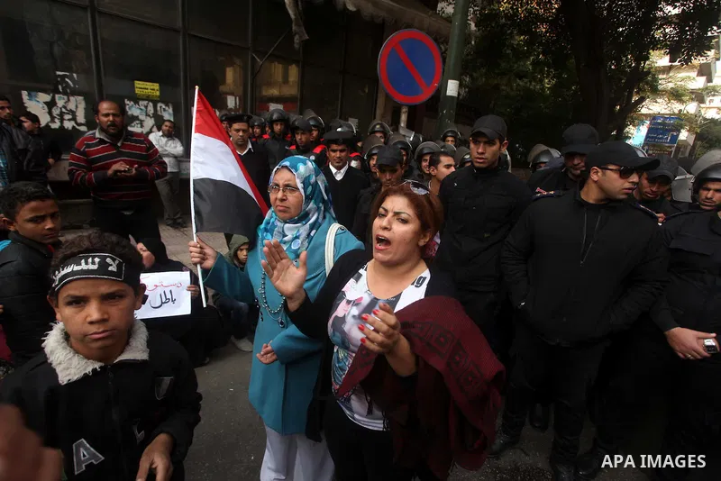 Egyptians women protest against the police officers near the Shura Council, the upper house of parliament where the Constituent Assembly drafted the country's new constitution, as protesters against Egypt's President Moh...