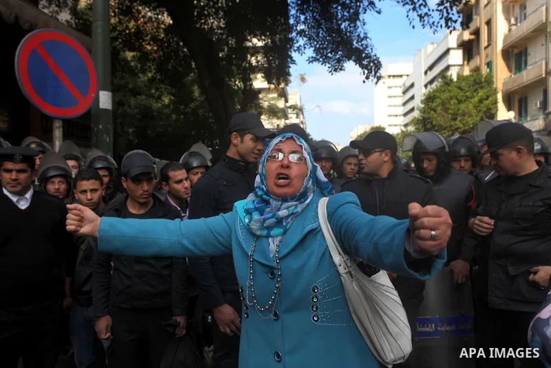 Egyptians women protest against the police officers near the Shura Council, the upper house of parliament where the Constituent Assembly drafted the country's new constitution, as protesters against Egypt's President Moh...
