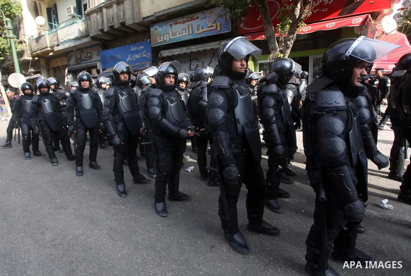 Egyptian riot police stand guard outside the Shura Council, the upper house of parliament where the Constituent Assembly drafted the country's new constitution, as protesters against Egypt's President Mohamed Morsi chant...