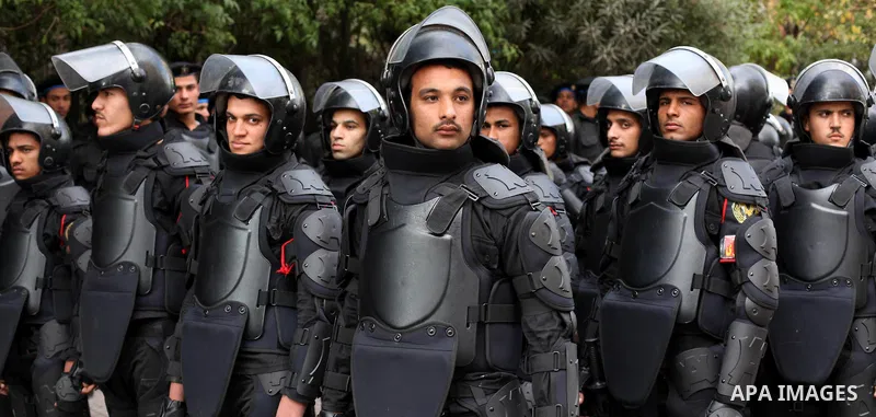 Egyptian riot police stand guard outside the Shura Council, the upper house of parliament where the Constituent Assembly drafted the country's new constitution, as protesters against Egypt's President Mohamed Morsi chant...