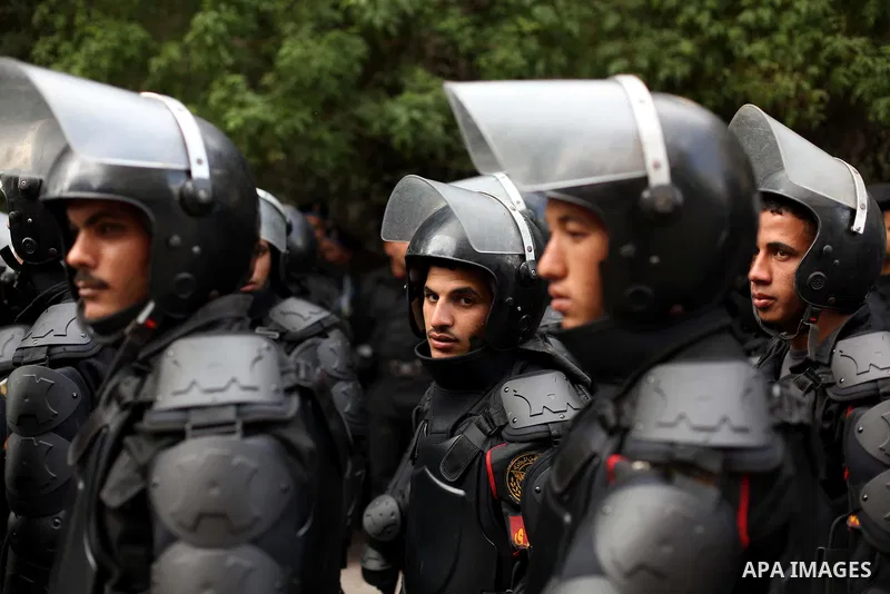 Egyptian riot police stand guard outside the Shura Council, the upper house of parliament where the Constituent Assembly drafted the country's new constitution, as protesters against Egypt's President Mohamed Morsi chant...