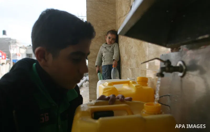 Palestinian children fill plastic bottles with drinking water in Rafah camp southern Gaza Strip, on Dec. 30, 2012. The residents of the Gaza strip suffer from lack of potable water, Israel continues to tighten its blocka...