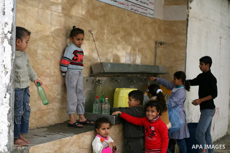 Palestinian children fill plastic bottles with drinking water in Rafah camp southern Gaza Strip, on Dec. 30, 2012. The residents of the Gaza strip suffer from lack of potable water, Israel continues to tighten its blocka...