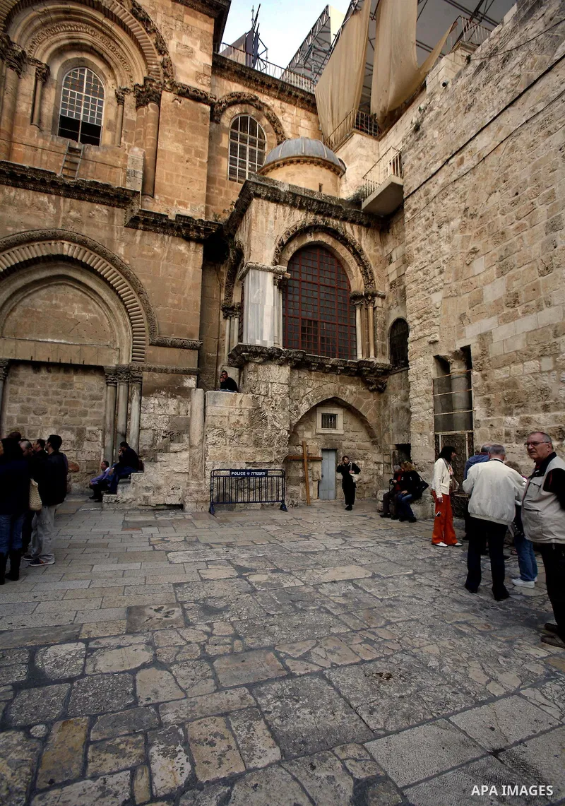 Palestinian and foreign worshippers walk outside the church of the Holy Sepulchre in Jerusalem's old city on December 30, 2012. The church has been a paramount - and for many Christians the most important - pilgrimage de...