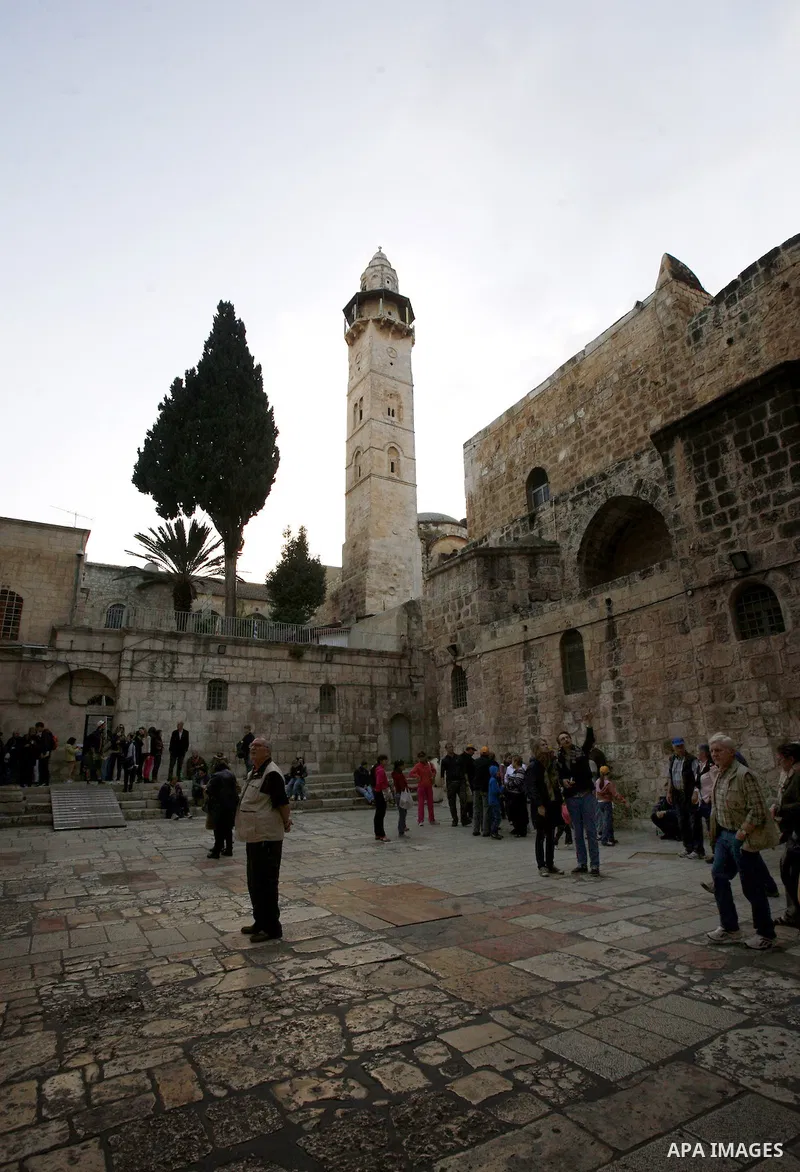 Palestinian and foreign worshippers walk outside the church of the Holy Sepulchre in Jerusalem's old city on December 30, 2012. The church has been a paramount - and for many Christians the most important - pilgrimage de...