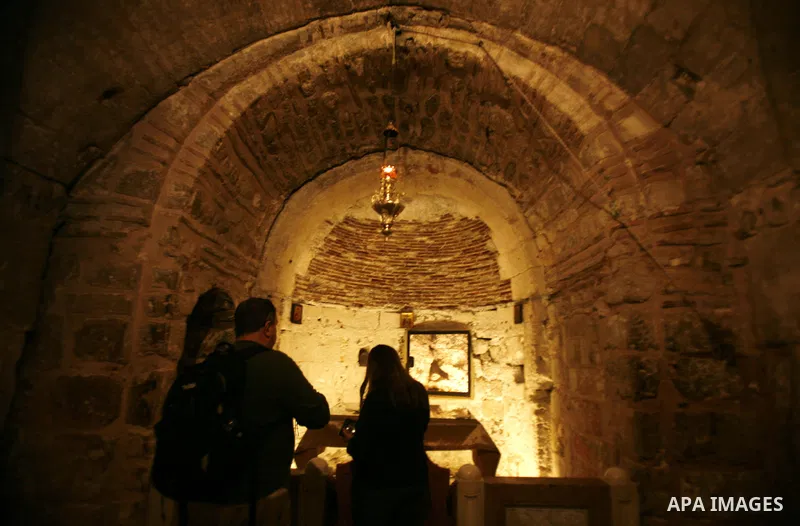 Palestinian and foreign worshippers walk outside the church of the Holy Sepulchre in Jerusalem's old city on December 30, 2012. The church has been a paramount - and for many Christians the most important - pilgrimage de...