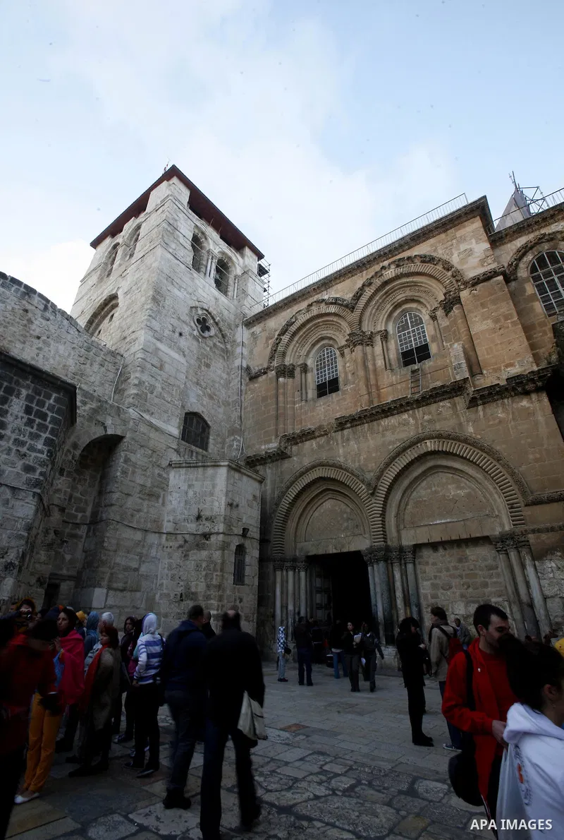 Palestinian and foreign worshippers walk outside the church of the Holy Sepulchre in Jerusalem's old city on December 30, 2012. The church has been a paramount - and for many Christians the most important - pilgrimage de...
