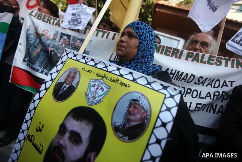Palestinians hold pictures of prisoners held in the Israeli jails during a rally in Gaza city on December 31, 2012. in solidarity with hunger-striking detainees held by Israel to demand their release from detention witho...