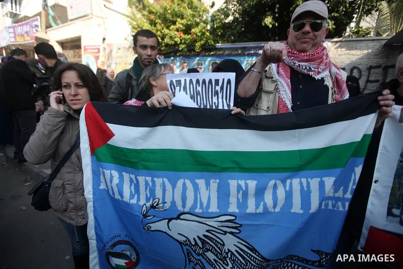 Palestinians and foreign protesters hold pictures of prisoners held in the Israeli jails during a rally in Gaza city on December 31, 2012. in solidarity with hunger-striking detainees held by Israel to demand their relea...