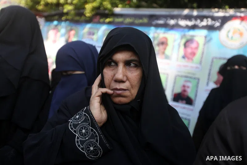 Palestinians hold pictures of prisoners held in the Israeli jails during a rally in Gaza city on December 31, 2012. in solidarity with hunger-striking detainees held by Israel to demand their release from detention witho...