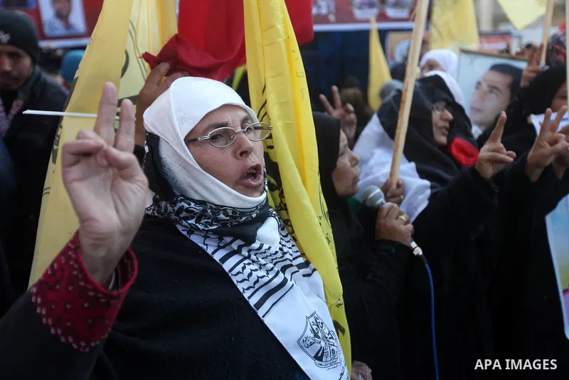 Palestinians hold pictures of prisoners held in the Israeli jails during a rally in Gaza city on December 31, 2012. in solidarity with hunger-striking detainees held by Israel to demand their release from detention witho...