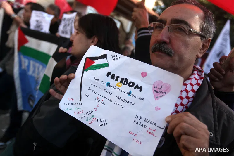 Palestinians and foreign protesters hold pictures of prisoners held in the Israeli jails during a rally in Gaza city on December 31, 2012. in solidarity with hunger-striking detainees held by Israel to demand their relea...