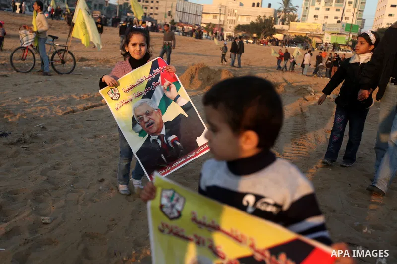 Palestinian children hold a pictures of Palestinian President Mahmoud Abbas during a rally in Gaza city on December 31, 2012. The Gaza branch of Palestinian president Mahmud Abbas's Fatah party said on Friday it will mar...