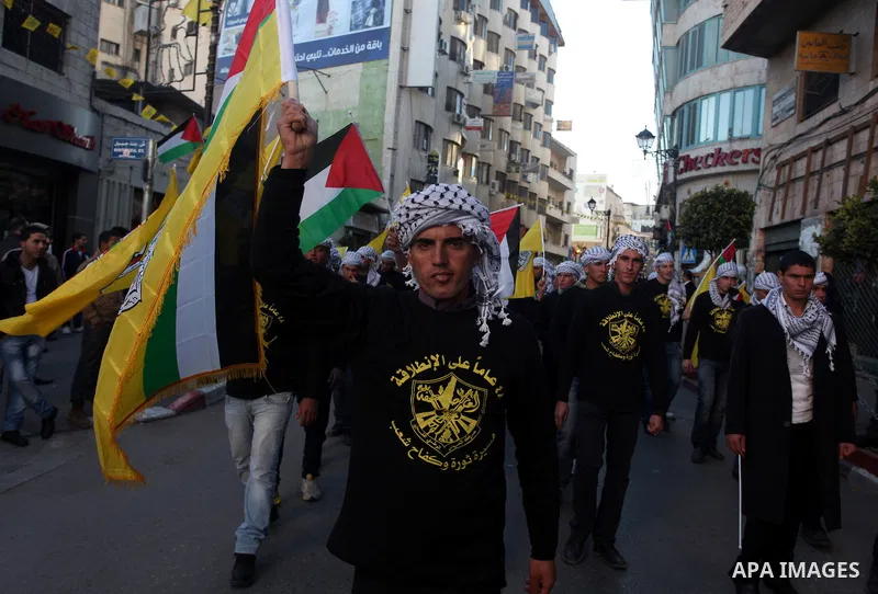 Palestinians wave their national flag during a rally on the eve of the 48th anniversary of the formation on the Fatah movement, on December 31, 2012, in the West Bank city of Ramallah. The Fatah anniversary commemorates...