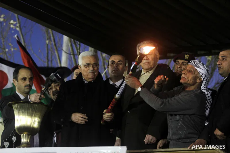 Palestinian President Mahmud Abbas lights a flame as thousands of Palestinians look on, on the eve of the 48th anniversary of the formation on the Fatah movement, on December 31, 2012, in the West Bank city of Ramallah....