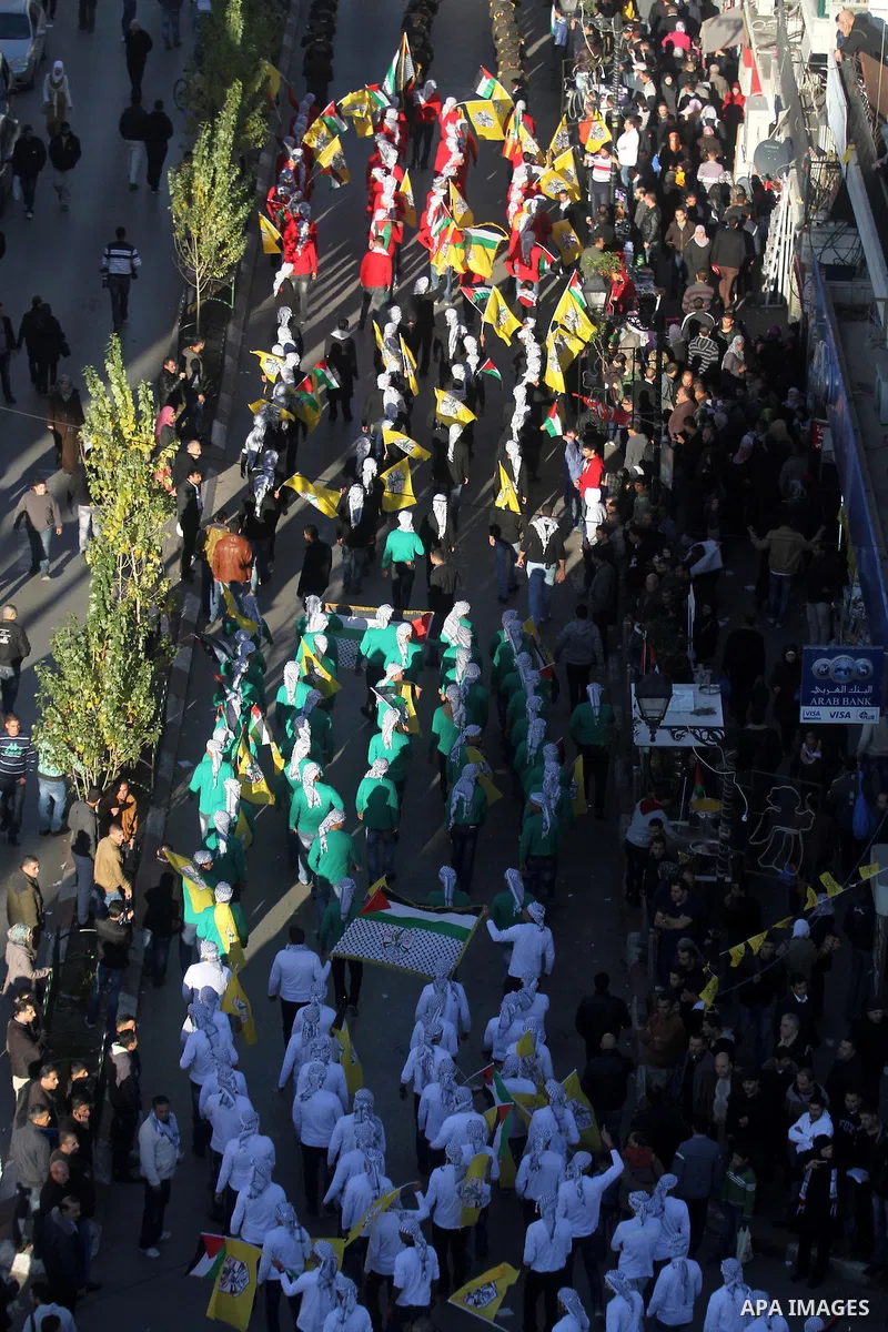 Palestinians wave their national flag during a rally on the eve of the 48th anniversary of the formation on the Fatah movement, on December 31, 2012, in the West Bank city of Ramallah. The Fatah anniversary commemorates...