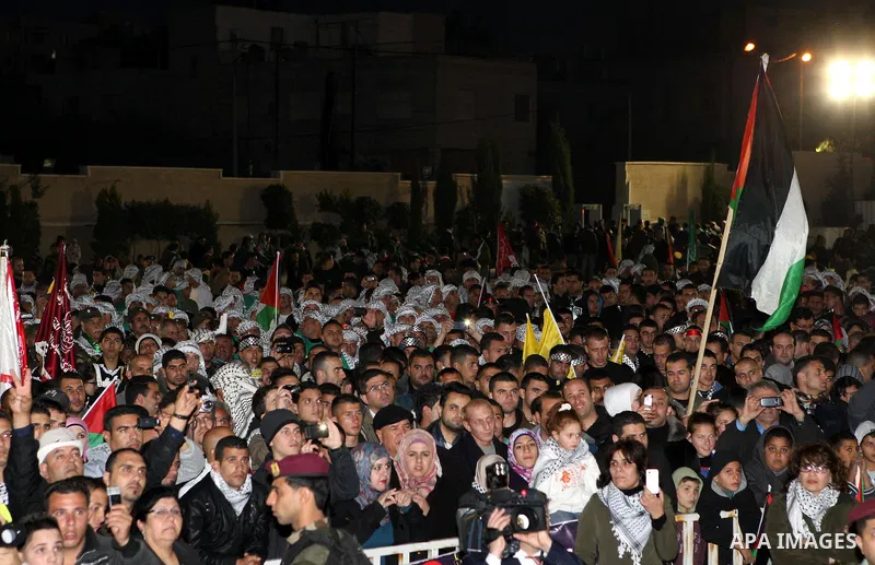 Palestinians wave their national flag during a rally on the eve of the 48th anniversary of the formation on the Fatah movement, on December 31, 2012, in the West Bank city of Ramallah. The Fatah anniversary commemorates...