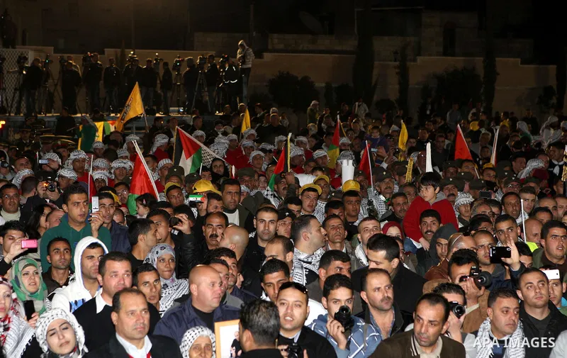 Palestinians wave their national flag during a rally on the eve of the 48th anniversary of the formation on the Fatah movement, on December 31, 2012, in the West Bank city of Ramallah. The Fatah anniversary commemorates...