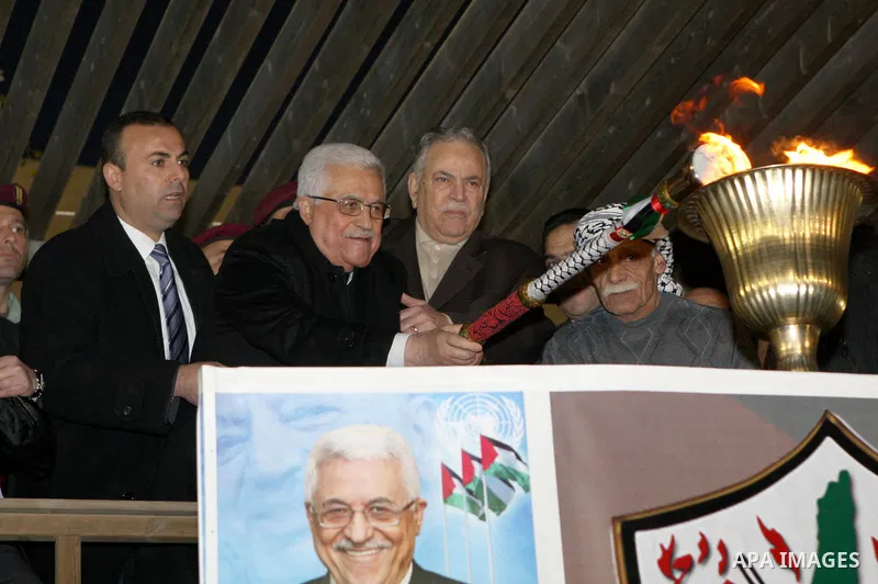 Palestinian President Mahmud Abbas lights a flame as thousands of Palestinians look on, on the eve of the 48th anniversary of the formation on the Fatah movement, on December 31, 2012, in the West Bank city of Ramallah....