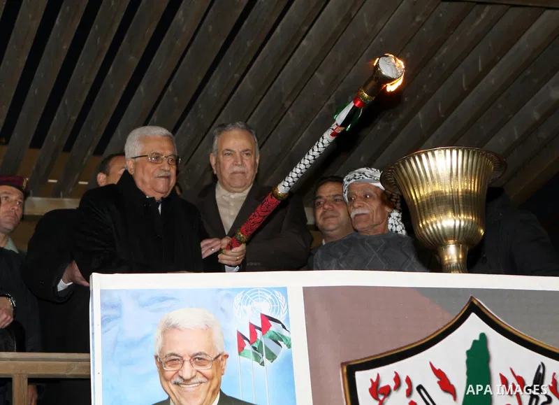 Palestinian President Mahmud Abbas lights a flame as thousands of Palestinians look on, on the eve of the 48th anniversary of the formation on the Fatah movement, on December 31, 2012, in the West Bank city of Ramallah....