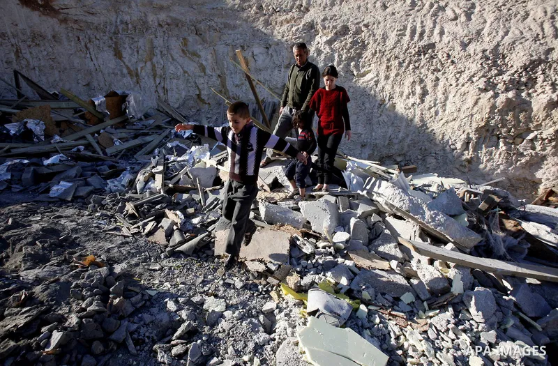 Palestinians search in the rubble of their house after it was demolished by Jerusalem municipality workers in the east Jerusalem on December 21, 2012. Palestinian homes built without a construction permit are often demol...