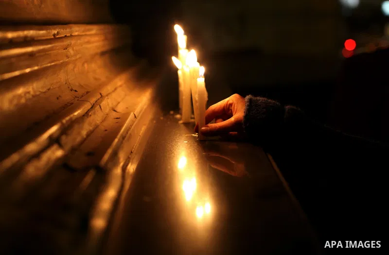 An Egyptian lights candles at the entrance of the Journalist's Syndicate in Cairo on December 31, 2012, during a rally to commemorate the anniversary of the car bomb attack on the al-Qiddissine (The Saints) church in the...