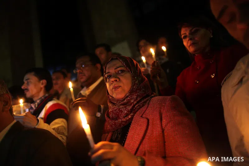 Egyptian activists hold candles as they take part in a rally on the anniversary of the attack on the All Saints Church (al-Qiddissine) in the city of Alexandria two years ago, as the gather on new Year's eve in front of...