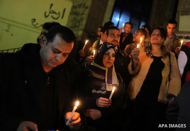 Egyptian activists hold candles as they take part in a rally on the anniversary of the attack on the All Saints Church (al-Qiddissine) in the city of Alexandria two years ago, as the gather on new Year's eve in front of...