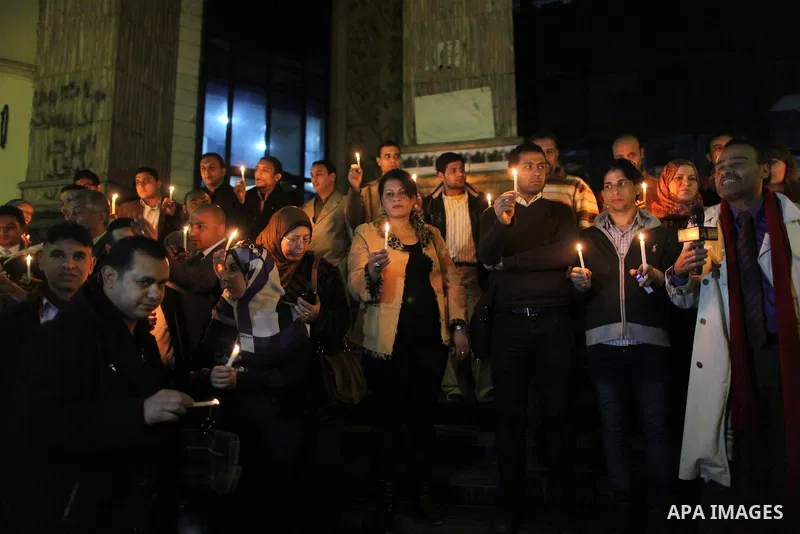 Egyptian activists hold candles as they take part in a rally on the anniversary of the attack on the All Saints Church (al-Qiddissine) in the city of Alexandria two years ago, as the gather on new Year's eve in front of...