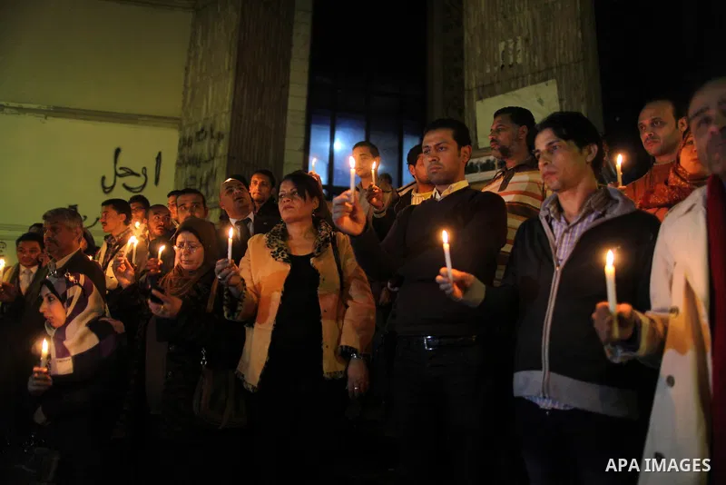 Egyptian activists hold candles as they take part in a rally on the anniversary of the attack on the All Saints Church (al-Qiddissine) in the city of Alexandria two years ago, as the gather on new Year's eve in front of...