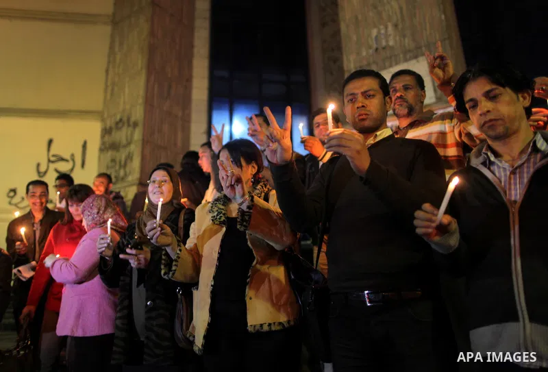 Egyptian activists hold candles as they take part in a rally on the anniversary of the attack on the All Saints Church (al-Qiddissine) in the city of Alexandria two years ago, as the gather on new Year's eve in front of...