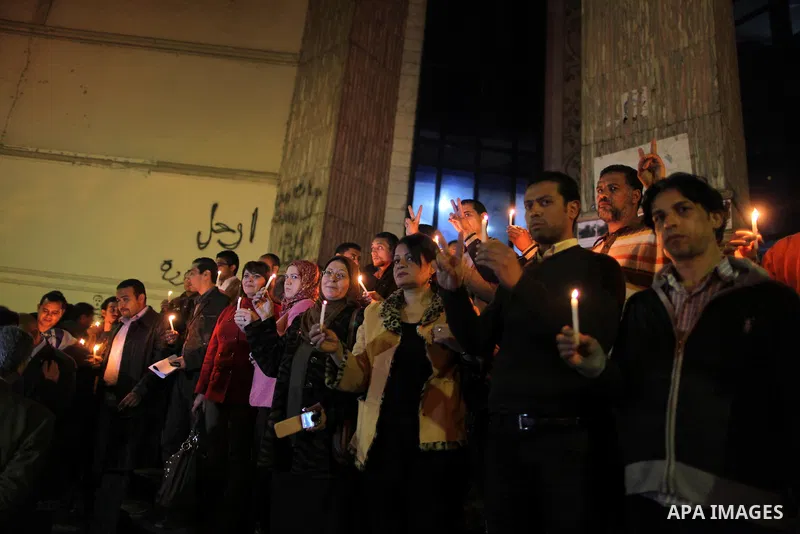 Egyptian activists hold candles as they take part in a rally on the anniversary of the attack on the All Saints Church (al-Qiddissine) in the city of Alexandria two years ago, as the gather on new Year's eve in front of...
