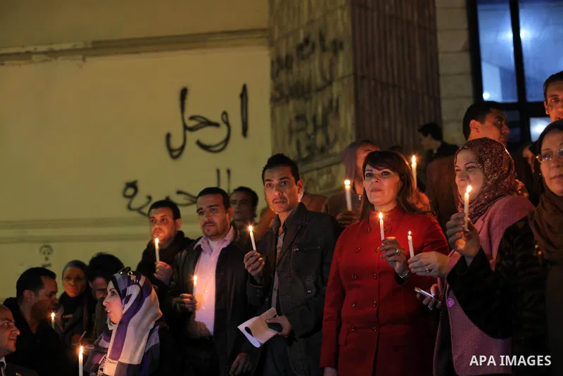 Egyptian activists hold candles as they take part in a rally on the anniversary of the attack on the All Saints Church (al-Qiddissine) in the city of Alexandria two years ago, as the gather on new Year's eve in front of...