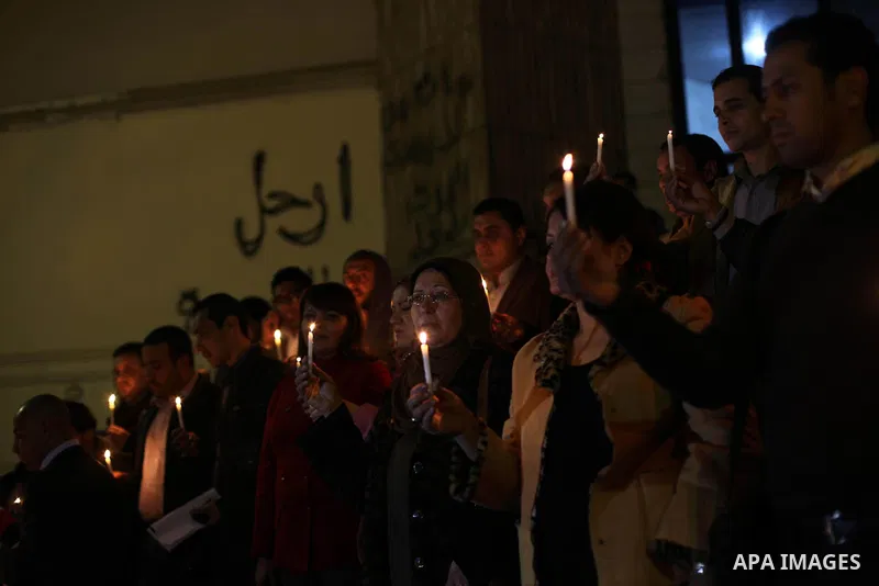 Egyptian activists hold candles as they take part in a rally on the anniversary of the attack on the All Saints Church (al-Qiddissine) in the city of Alexandria two years ago, as the gather on new Year's eve in front of...