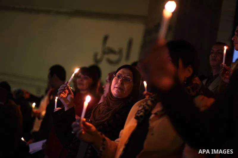 Egyptian activists hold candles as they take part in a rally on the anniversary of the attack on the All Saints Church (al-Qiddissine) in the city of Alexandria two years ago, as the gather on new Year's eve in front of...