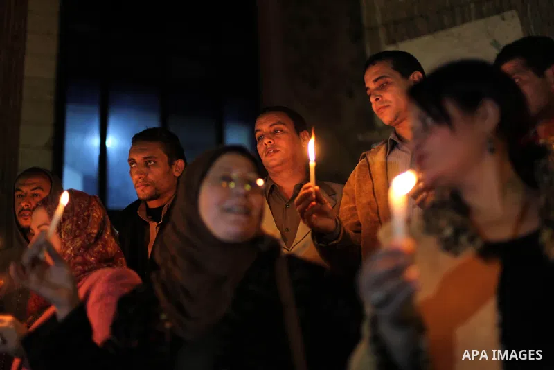 Egyptian activists hold candles as they take part in a rally on the anniversary of the attack on the All Saints Church (al-Qiddissine) in the city of Alexandria two years ago, as the gather on new Year's eve in front of...