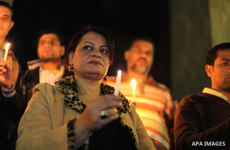 Egyptian activists hold candles as they take part in a rally on the anniversary of the attack on the All Saints Church (al-Qiddissine) in the city of Alexandria two years ago, as the gather on new Year's eve in front of...