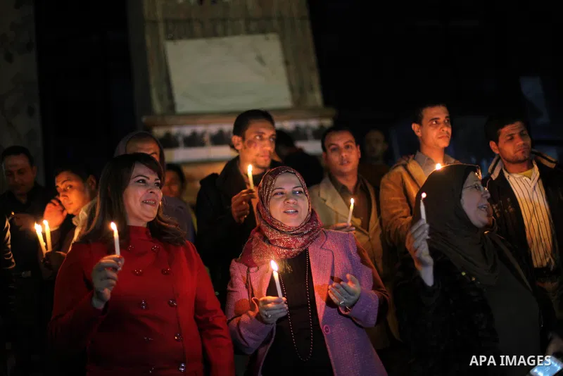 Egyptian activists hold candles as they take part in a rally on the anniversary of the attack on the All Saints Church (al-Qiddissine) in the city of Alexandria two years ago, as the gather on new Year's eve in front of...
