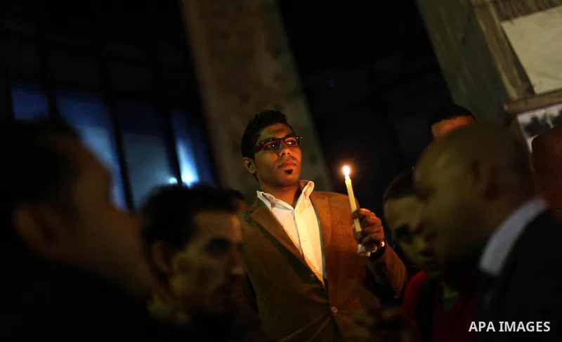 Egyptian activists hold candles as they take part in a rally on the anniversary of the attack on the All Saints Church (al-Qiddissine) in the city of Alexandria two years ago, as the gather on new Year's eve in front of...