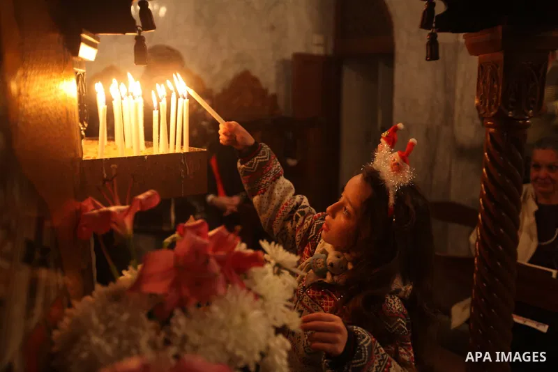 A Palestinian Orthodox Christian child lights a candle in a church during Christmas celebrations on January 7, 2013 in Gaza City. According to the Gregorian calendar, Orthodox Christmas falls 13 days after the December 2...