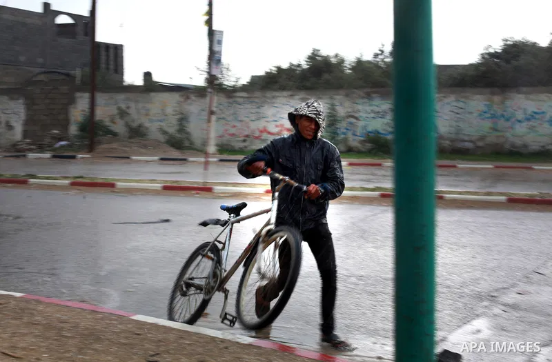A Palestinian man rides bicycle through floodwater in the central Gaza Strip January 10, 2013. A storm has hit the eastern Mediterranean coast and heavy rains with flooding are forecast in Israel and the Palestinian terr...