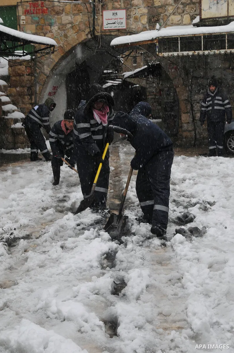 Palestinian security shovels snow outside of the Ibrahami Mosque or the Tomb of the Patriarchs in the West Bank City of Hebron as wintry weather swept through the region 10 January 2013. Photo by Mamoun Wazwaz