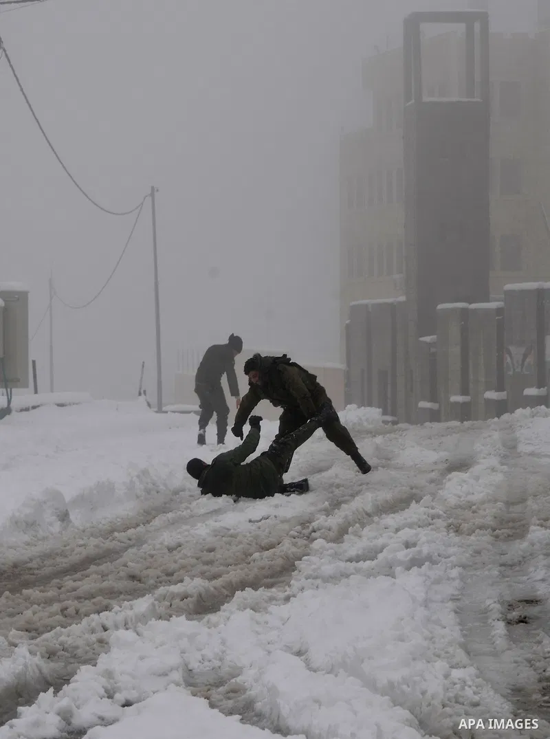 Palestinian security personnel engage in a snowball fight near their headquarters in the West Bank city of Hebron 10 January 2013. The higher elevations in the Palestinian Authority areas and Israel, including Jerusalem,...