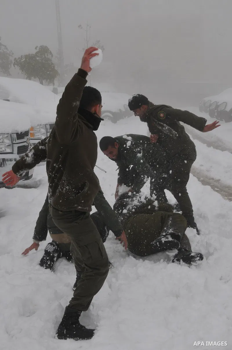 Palestinian security personnel engage in a snowball fight near their headquarters in the West Bank city of Hebron 10 January 2013. The higher elevations in the Palestinian Authority areas and Israel, including Jerusalem,...