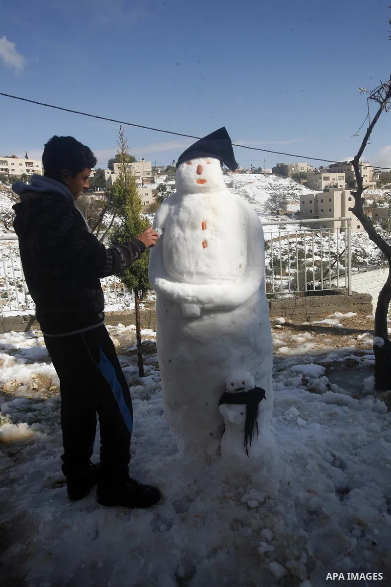 Palestinians walk at Al-Aqsa mosque compound as snow falls in the old city of Jerusalem on January 10, 2013. Jerusalem was transformed into a winter wonderland after heavy overnight snowfall turned the Holy City and much...