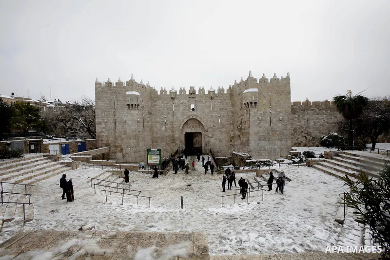 Palestinians walk at Al-Aqsa mosque compound as snow falls in the old city of Jerusalem on January 10, 2013. Jerusalem was transformed into a winter wonderland after heavy overnight snowfall turned the Holy City and much...