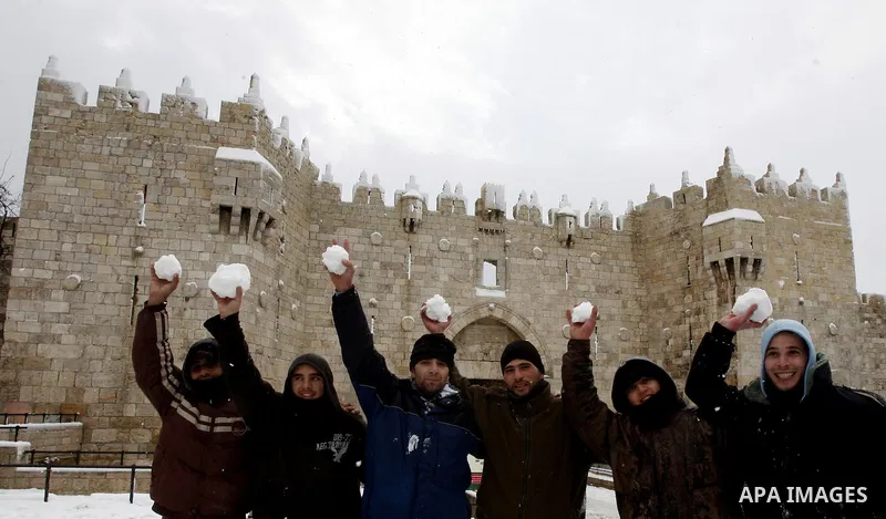 Palestinian children play with snow balls at the Al-Aqsa mosque compound in the old city of Jerusalem on January 10, 2013. Jerusalem was transformed into a winter wonderland after heavy overnight snowfall turned the Holy...