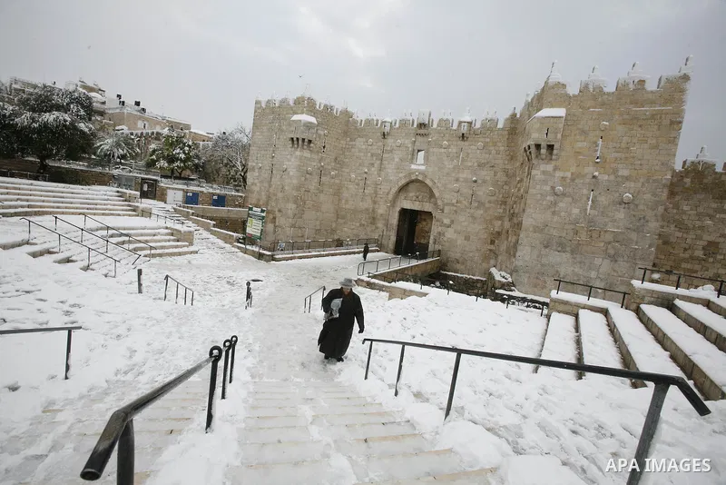 An ultra-orthodox Jewish man walks as snow falls at the Al-Aqsa mosque compound in the old city of Jerusalem on January 10, 2013. Jerusalem was transformed into a winter wonderland after heavy overnight snowfall turned t...