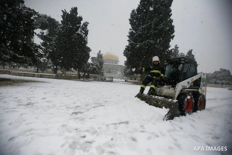 Palestinians try to remove the snow at the Al-Aqsa mosque compound in the old city of Jerusalem on January 10, 2013. Jerusalem was transformed into a winter wonderland after heavy overnight snowfall turned the Holy City...