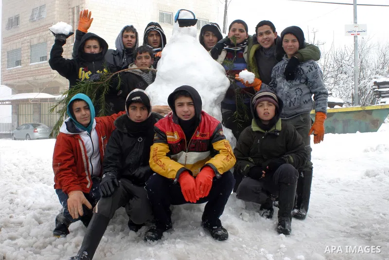 Palestinian children in the snow balls in the West Bank city of Hebron on January 10, 2013. Abnormal storms, which for four days have blasted the Middle East with rain, snow and hail, leave swathes of Israel and Jordan u...
